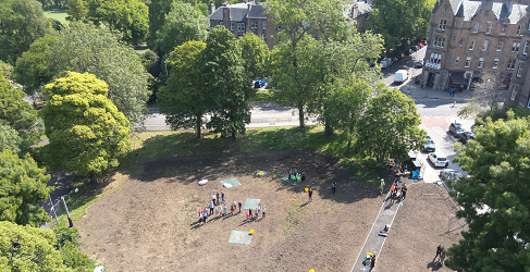 This aerial shot shows school pupils planting on the meadow site