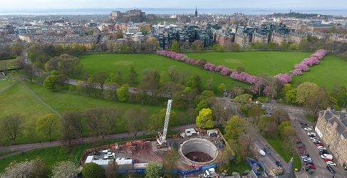 This aerial shot shows the storm tank underneath Bruntsfield Links during construction. Lines of cherry blossom on the Meadows are shown in the background