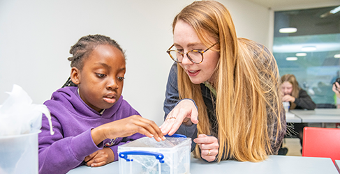A young schoolgirl and her female teacher from St Pius Primary School in Dundee busy with a water experiment at Scottish Water Generation H2O Water cycle workshop 