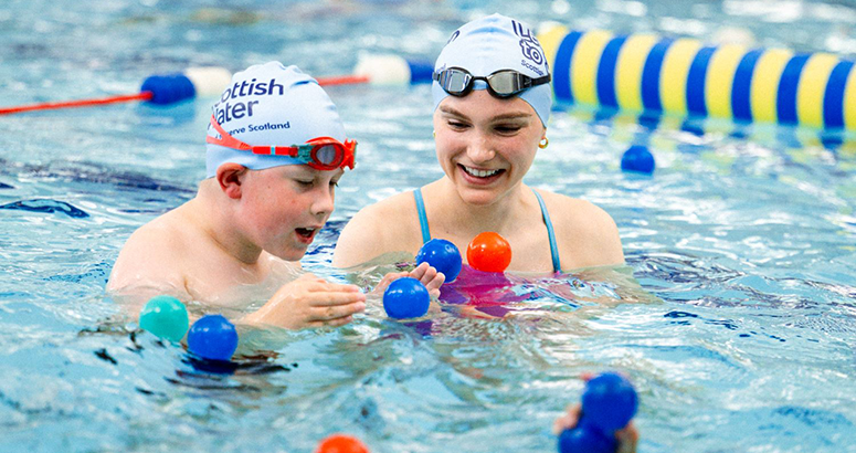 Paralympian swimmer Toni Shaw with a young boy in a swimming pool at a Learnt o Swim lesson