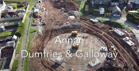 aerial shot of park with construction site in middle and houses around it